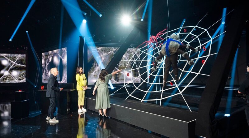 Das große Netz-Quiz: vl.n.r. Johannes B. Kerner, Moderatorin Esther Sedlaczek und Nilam Farooq am Mega-Spinnennetz. Im Spinnenkostüm steckt Teamkapitän Wincent Weiss. „Die große Maus-Show“, am 28.06.2025 um 20 Uhr 15 im Ersten und in der ARD Mediathek. – Bild: WDR/​Ben Knabe