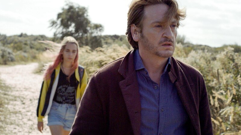 Lola ist 18, hat pinke Haare und macht gerade ihr Diplom als Veterinär-Assistentin. Als ihre Mutter Catherine stirbt, sorgt ihr Vater Philippe dafür, dass sie die Trauerfeier verpasst. Vor zwei Jahren hat Philippe den Kontakt zu ihr abgebrochen, weil er das Trans-Outing „seines Sohns“ nicht akzeptieren konnte. Doch Lola ist entschlossen, ihrer Mutter den letzten Wunsch zu erfüllen. – Widerwillig machen sich Vater (Benoît Magimel, re.) und Tochter (Mya Bollaers) auf die gemeinsame Reise. – Bild: rbb/​Salzgeber