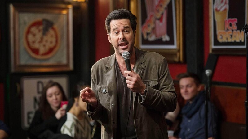 Der sozialkritische Satiriker Josh Galloway (Jonathan Silverman) ist bekannt für seine äußerst kontroversen Vorträge bezüglich der Rolle der Frau und seine mit sexistischem Humor geschmückten Äußerungen über das Thema Vergewaltigung. – Bild: TVNOW /​ NBC Universal