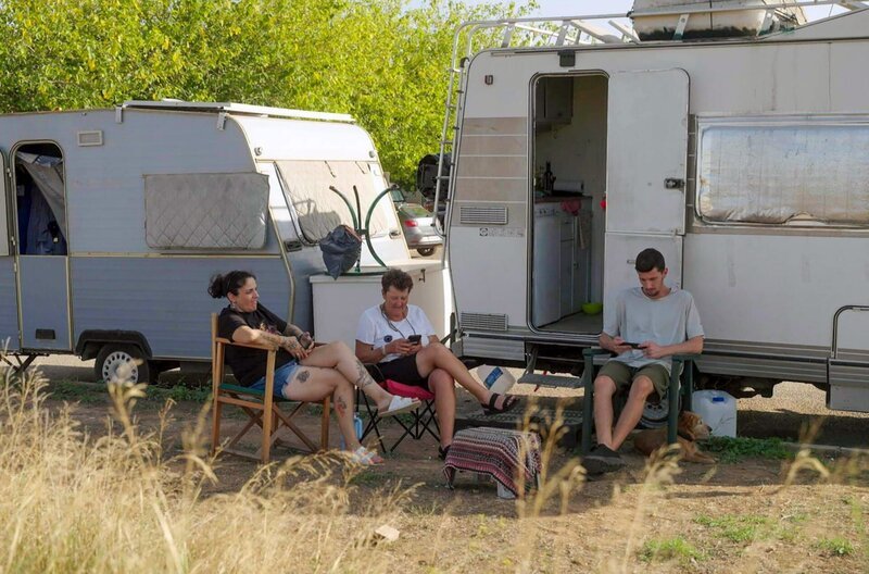 Begona Iglesias (li.) und ihr Sohn Hector (re.) entspannen nach der Arbeit zusammen mit ihrer Nachbarin Ana (Mi.) vor ihrem gemieteten Wohnmobil. – Bild: Henning Drechsler
