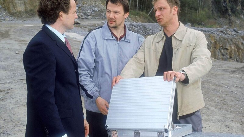 v.li.: Schneider übergibt an die Entführer Frank und Harry den Geldkoffer. Die beiden Gangster glauben sich am Ziel ihrer Wünsche. – Bild: MG RTL D /​ Kai Schulz