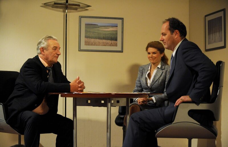 Hubert ist sprachlos, als er von Klaus Sternbacher den Posten der Geschäftsführung angeboten bekommt. Von links: Klaus Sternbacher (Josef Thalmeier), Uschi Guggenmoser (Silke Popp) und Hubert Kirchleitner (Bernhard Ulrich). – Bild: BR/​Marco Orlando Pichler