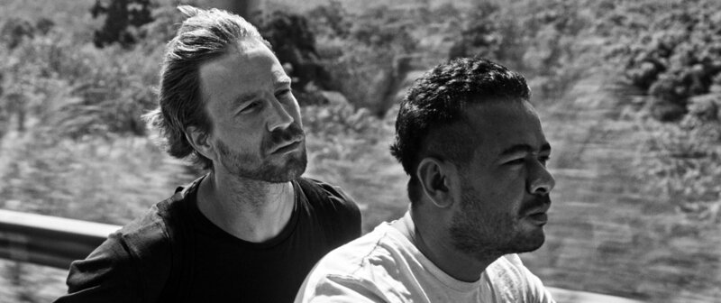 Leo (Ilja Stahl, li.) und Mawar (Sabree Matming, re.) sind auf der Suche nach Kontakten für Leos Reportage. – Bild: MDR/Falco Seliger Leo (Ilja Stahl, li.) und Mawar (Sabree Matming, re.) sind auf der Suche nach Kontakten für Leos Reportage. – Bild: MDR/Falco Seliger