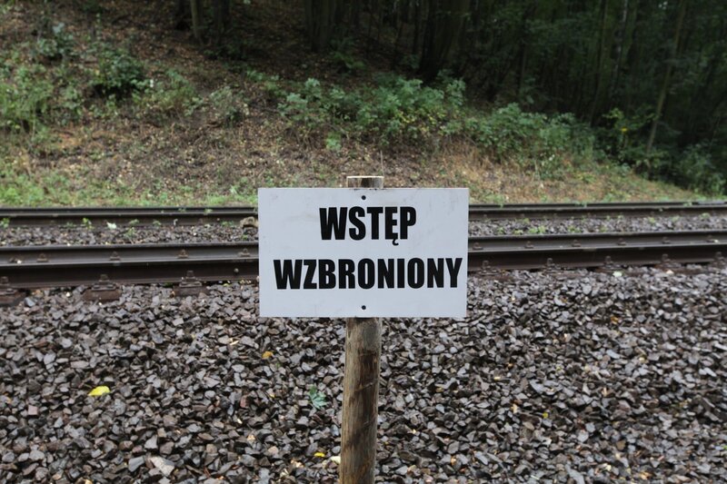 Schild in polnischer Sprache an Eisenbahnlinie: „Kein Zutritt“. – Bild: ZDF/​Norbert Hans