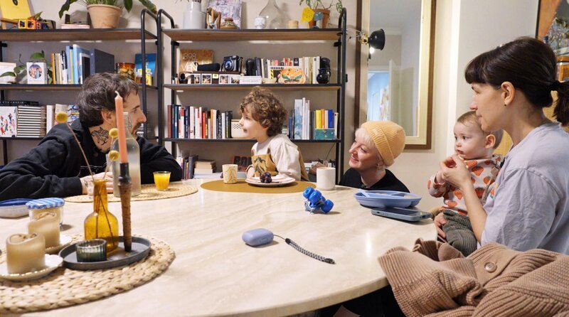 Selbst beim idyllischen Familienfrühstück fühlen Adrià (links) und seine Frau Anne (ganz rechts) ein unerklärliches Gefühl von Einsamkeit. – Bild: Radio Bremen/Michael Strategies Selbst beim idyllischen Familienfrühstück fühlen Adrià (links) und seine Frau Anne (ganz rechts) ein unerklärliches Gefühl von Einsamkeit. – Bild: Radio Bremen/Michael Strategies