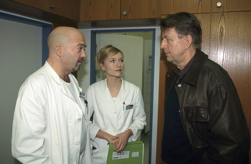 2. EKHK Joe Hoffer ist zu Dr. Christoph Emde auf der herzchirurgischen Station gekommen, um ihn zum Tod von Prof. Koppeck zu befragen. Oberschwester Ruth Hoog ist Zeugin des Gesprächs. – Bild: Katrin Knoke