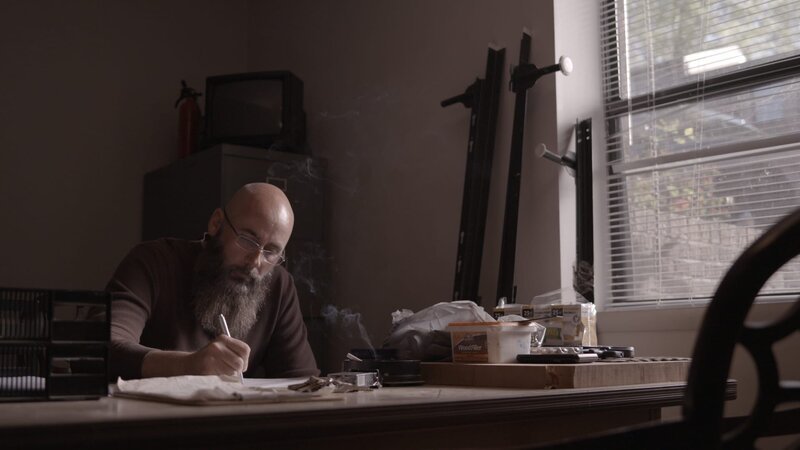 Bearded man sits with smoke in the air. – Bild: Investigation Discovery /​ Discovery Communications