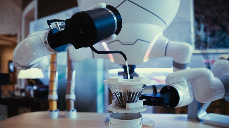 Ein Roboter macht Kaffee in der Hotellobby. – Bild: Benedikt Nabben /​ BR