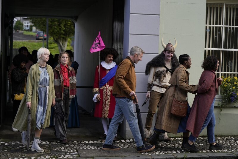 Frank (Zac Looker, 3.v.l.) führt die Interessierten (Komparsen) auf einer historischen Tour durch Juniper. Wenn Bonnie (Ella Maisy Purvisdas, l.) nicht die unschönen Fakten über Juniper äußern würde, wäre die Stadtführung ein voller Erfolg. Keedie (Georgia De Gidlow, 2.v.l.) versucht mit ihr zu reden, aber Bonnie reagiert mit Feindseligkeit. – Bild: Kind Of Productions Limited MMX /​ ZDF und Kind Of Productions Lim /​ Honorarfrei – nur für diese Sendung inkl. SocialMedia bei Nennung ZDF und Kind Of Productions Limited MMXXIV.