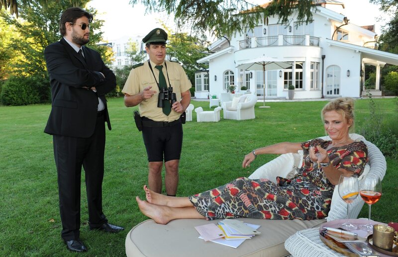Der Wachmann (Dominik Zahorka, l.) bringt den heimlichen Fan Riedl (Paul sedlmeir, M.) zu Claudia Brenner (Ursula Gottwald, r.). – Bild: Leonine