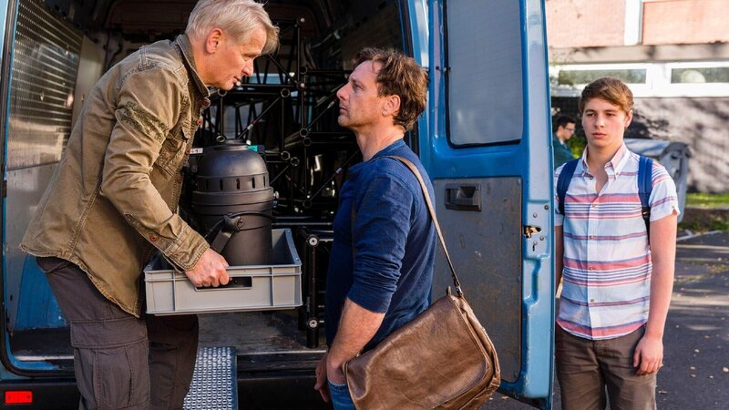 Stefan Vollmer (Hendrik Duryn, M.) spricht mit Tim Wenk (Horst Kotterba, l.), der seinen Sohn Ole für ein Weichei hält. Ole (Matti Schmidt-Schaller) bekommt das Gespräch mit. – Bild: TVNOW /​ Frank Dicks