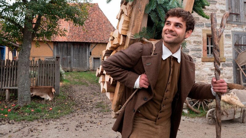 Hans (Lucas Reiber) trägt Holz. – Bild: ZDF und BR/​Michael Boxrucker