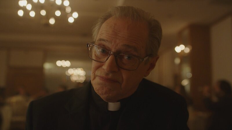 Pater Mac (Steve Buscemi) versucht Pete auf ungewöhnliche Weise begreiflich zu machen, dass sein verstorbener Vater nicht fort ist – sondern mitten unter ihnen. – Bild: ZDF und Peacock