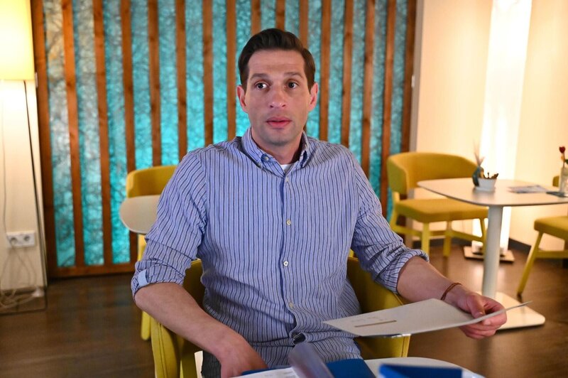 Deniz (Igor Dolgatschew) tröstet sich mit beruflichem Erfolg. – Bild: RTL /​ Julia Feldhagen /​ Sag ich’s oder sag ich’s nicht