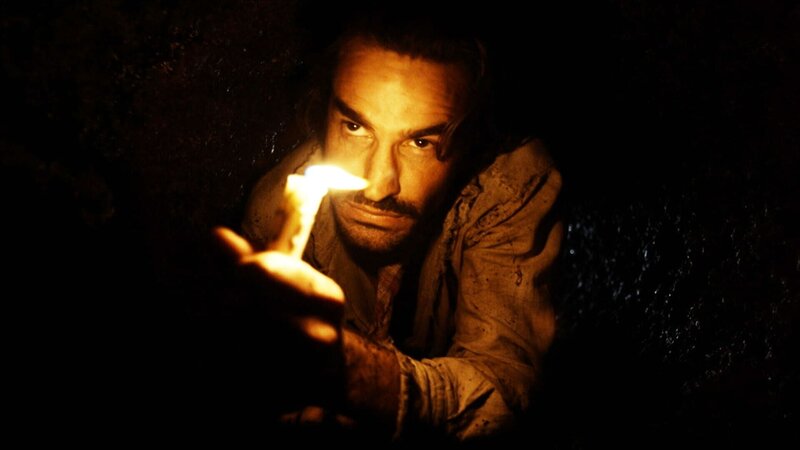 Ein Mann hält eine Kerze in seiner Hand. – Bild: THE HISTORY CHANNEL /​ A+E Networks