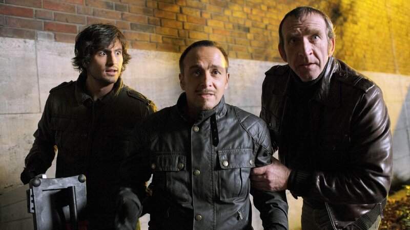 Ben (Tom Beck, l.) und Semir (Erdogan Atalay, M.) haben Charly (Jochen Nickel) geholfen, den Koffer mit den Sprengschnüren zu klauen. Als die Alarmanlage losgeht, müssen sie fliehen … – Bild: TVNOW /​ Guido Engels