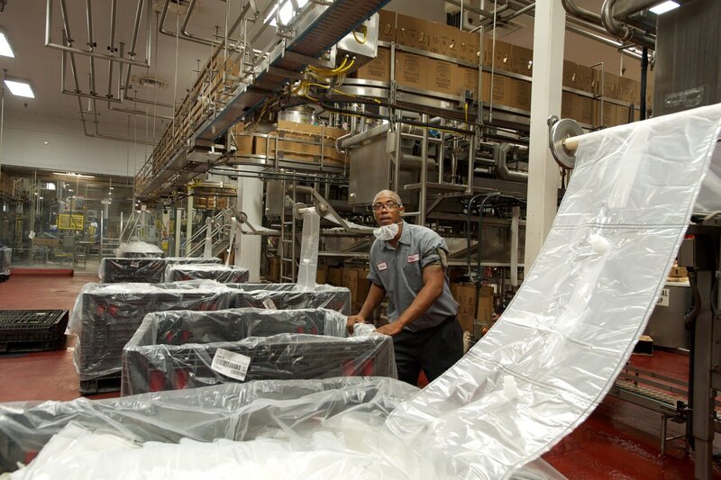Atlanta, GA, USA: In der Sirupfabrik von Coca-Cola in Atlanta, GA, justiert Eric Atkins eine Palette mit dreilagigen Plastikbeuteln, die als Behälter für den Sirup dienen, der in Springbrunnenspendern an Orten wie Schnellrestaurants verwendet wird. – Bild: CH Media/​NGT/​Cleared for all media, worldwide in perpetuity with promotion of the program and series. NO SALES, NO TRANSFERS./​Paul Sauer