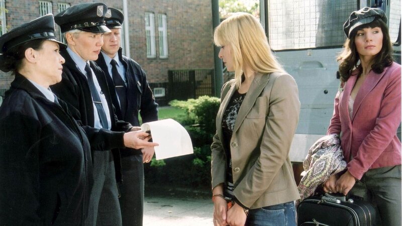 Die Beamten (v.li.: Karin Oehme, Uta Prelle, Komparse) nehmen die neuen Insassinnen Annika (Sylwia von Wildburg) und Ginger (Nadine Warmuth) in Empfang. – Bild: TVNOW /​ Richard Hübner