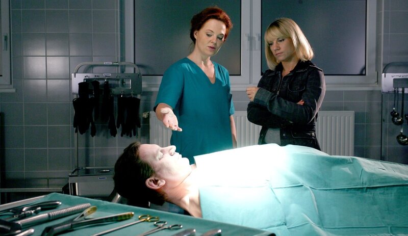 „Soko Kitzbühel“, „Jedermanns Tod.“ Nach einer seiner preisgünstigen Naturbestattungen, bei denen die Asche der Verstorbenen auf einer Wiese verstreut wird, bricht Franz Kubek am Steuer seines Wagens zusammen. Wie sich herausstellt, ist er vergiftet worden. Man möchte es kaum glauben, aber es sieht alles so aus, als wäre Kubek Opfer eines Konkurrenzkampfes im Bestattungsmilieu geworden. Werner Baumgartner, der Besitzer eines traditionsreichen Beerdigungsinstitutes, fühlte sich von Kubeks Diskontangeboten angegriffen und hat ihm sogar mehrmals gedroht. Von Brigitte Artner, die ein privates Krematorium führt und Kubeks Geschäftspartnerin war, erfahren Karin und Lukas von der zweiten Seite in Kubeks Leben: Er war leidenschaftlicher Hobby-Schauspieler. In seiner Laientruppfe finden sich so illustre Mitglieder wie der Notar Joachim Neuhofer und der Ex-TV-Star Gerhard Moser. Letzterer verdient sich sein Geld mit Grabreden beim Institut Baumgartner. Seinen Popularitätsverlust hat er jedoch nie verkraftet – und man fragt sich schon, ob Kubek nicht damit zu tun haben könnte.Im Bild (v.li.): Christine Klein (Dr. Haller), Kristina Sprenger (Karin Kofler). – Bild: ORF/​BEO-Film/​Stella von Saldern