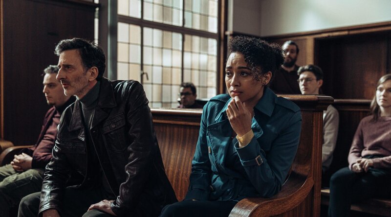 Paul Rabbit (l. Andy Gathergood) und Lisa Donckers (r. Emma Naomi) verfolgen den Prozess gegen Sean Hallett. – Bild: WDR/​Eagle Eye Drama/​Sofie Gheysens