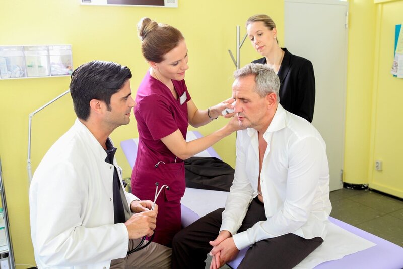 Dr. Behring (Maximilian Grill, l.) und Betty (Bettina Lamprecht, 2.v.l.) befürchten, dass Rolf Dehler (Tim Wilde, 2.v.r.) sie anlügt, als er im Beisein seiner Freundin Sophia (Katharina Kaali, r.) vorgibt, kürzlich nicht in Hongkong gewesen zu sein. – Bild: ORF/​ZDF/​Willi Weber