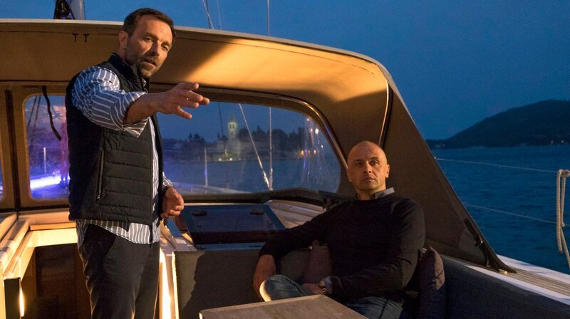 „Skipper“ Lado (Aleksandar Jovanovic) hat den Mordverdächtigen Zoran Horvath (Michael Rotschopf, re.) an Bord und zeigt ihm den Weg. – Bild: ARD Degeto/​Erika Hauri