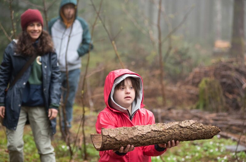 Toni (Anna Malner) hat von Dina (Maya Haddad) das perfekte Stück Rinde für Helenas Geburtstagsgeschenk bekommen. Im Hintergrund: Tim (Noah Boehm) – Bild: ARD/​Maria Wiesler