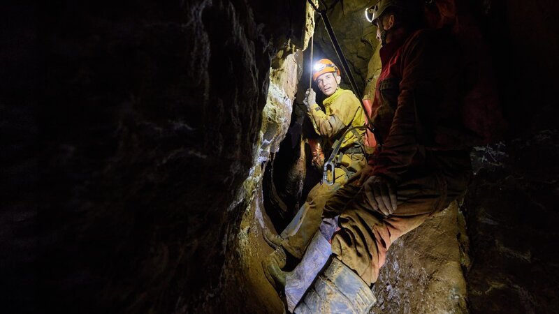 „PUR+“-Moderator Eric Mayer steigt mit einem Höhlenforscher hinab in das Windloch – eine Höhle mitten in Deutschland. – Bild: ZDF
