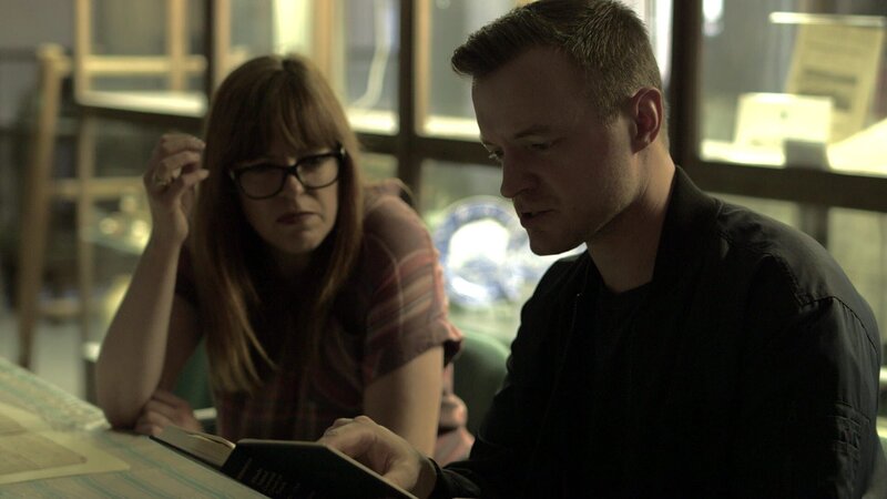 Paranormal investigators Adam Berry and Amy Bruni read the original transcript of the 1673 murder trial of Thomas Cornell at the Portsmouth Historical Society. – Bild: Travel Channel. /​ Scripps (Focus): TKSP503_7 /​ Travel Channel.