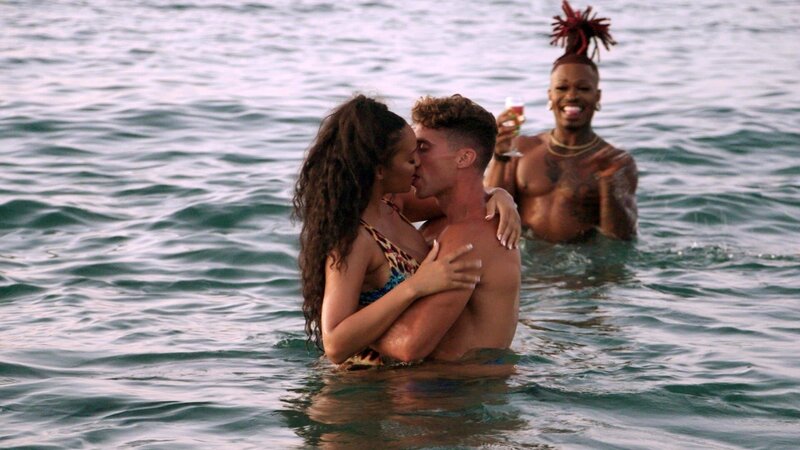 Chantel and Giannis kissing in the water while Moonie cheers them on – Bild: Warner Bros. Discovery, Inc. or its subsidiaries and affiliates.
