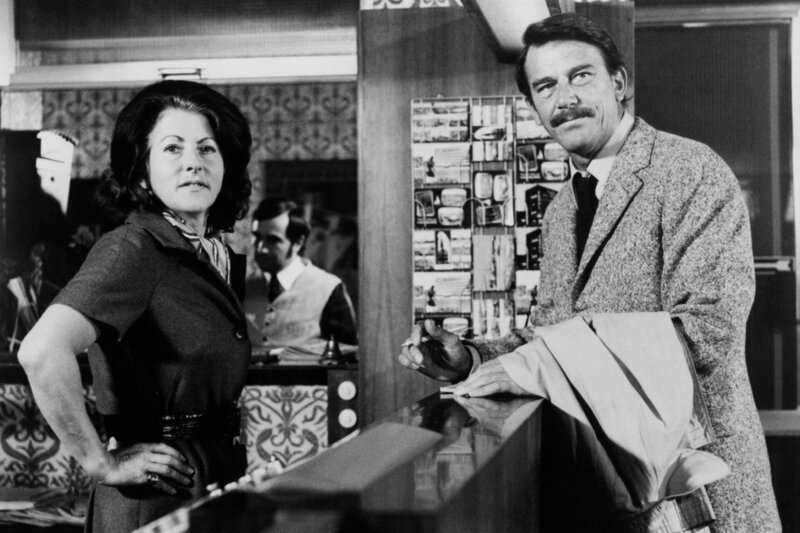 Die neue Empfangsdame begrüßt den Detektiv Fisher ahnungslos als Stammgast George Winters. – Bild: NDR/​Lilo-Foto