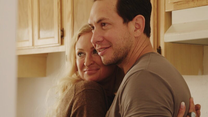 Natalie and Josh hug and smile in kitchen – Bild: Warner Bros. Discovery, Inc. or its subsidiaries and affiliates