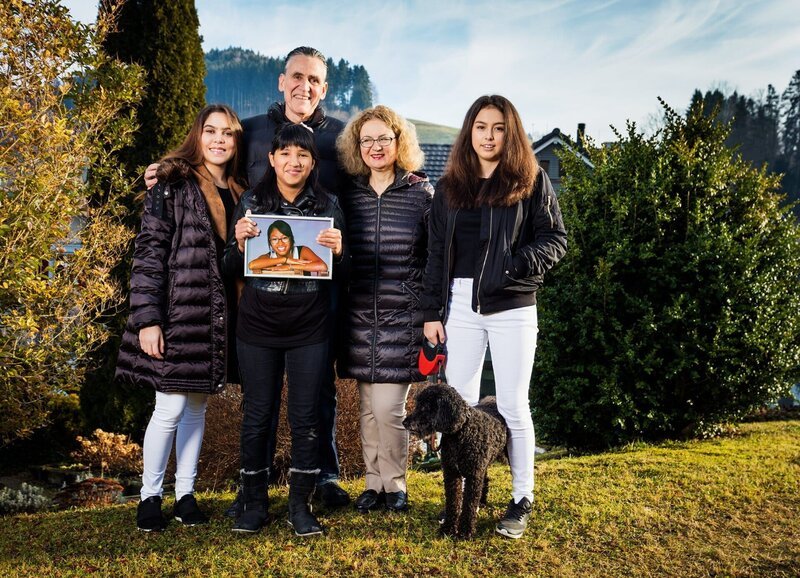 Familie Hunkeler Flück: Paulina Gongora, Viktor Hunkeler, Yuri Hunkeler mit einem Bild von Carmela Hunkeler, Denise Hunkeler Flück und Atalia Hunkeler mit Hund Theres – Bild: SRF