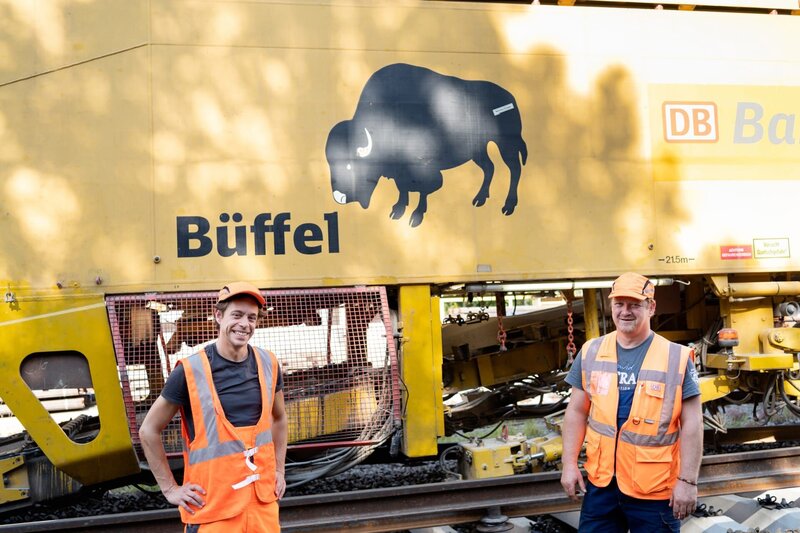 Mit Projektleiter Martin checkt Tobi welches Spezialfahrzeug neue gegen alte Zuggleise austauschen kann. – Bild: BR/​megaherz gmbh/​Hans-Florian Hopfner