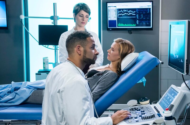 Dr. Matteo Moreau (Mike Adler, v.) und Dr. Theresa Koshka (Katharina Nesytowa, h.) führen bei Natalie Reichelt (Rike Kloster, r.) eine Ultraschall-Untersuchung durch. – Bild: ARD/​Jens Ulrich Koch