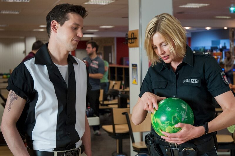 Melanie (Sanna Englund) hat noch ein paar Fragen an den Ersthelfer vom Unfallort, David Bachmann (Ole Lagerpusch), und sucht ihn deshalb im Bowlingcenter auf. – Bild: ZDF und Boris Laewen (bola)