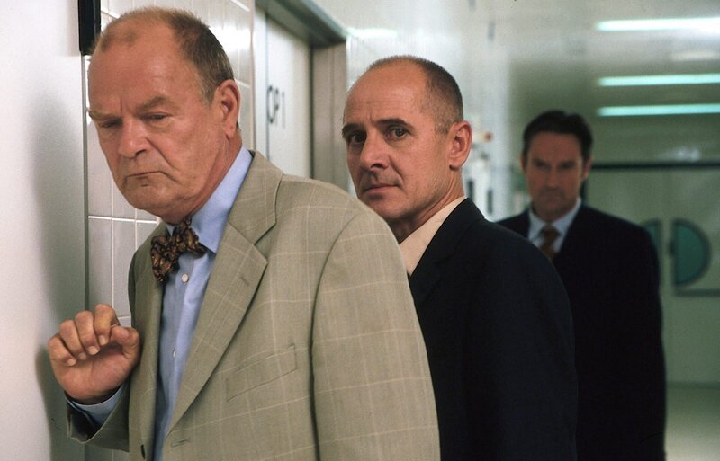 Dr. Robert Kolmaar (Ulrich Mühe, M.) versucht Prof. Bondzio (Dieter Mann, l.) beizustehen, dessen Frau bei der Operation gestorben ist. Verwaltungsdirektor Dr. Hans Leukers (Helmut Zierl, r.) fürchtet um den Ruf der Klinik. – Bild: ZDF