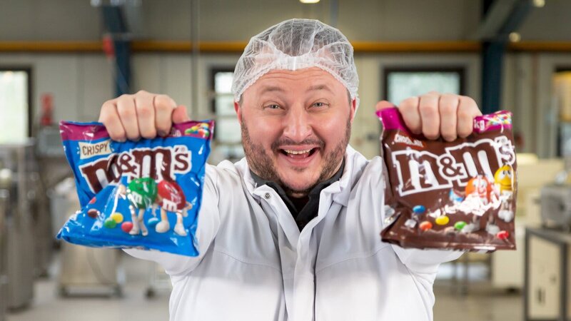 Mars produziert die wohl bekanntesten Schokolinsen der Welt. Aber wie werden m&m’s eigentlich hergestellt? Produktentwickler Sebastian Lege findet es heraus. – Bild: ZDF