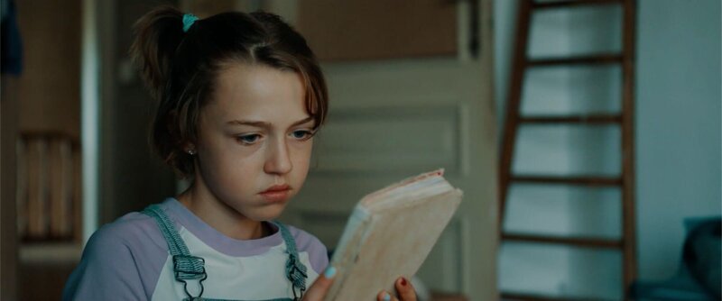 Ella (Cécile Enthoven) hält das alte Notizbuch von Felix’ Mutter in der Hand. – Bild: BR/​VRT/​Nico Surings