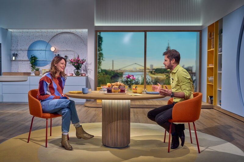 Nina (Lavinia Wilson) ist mit ihrem Kita-Gründungsratgeber und Bestseller „Andere Eltern“ bei Volle Kanne-Moderator Florian Weiss zum Frühstücksfernsehen eingeladen. – Bild: ZDF