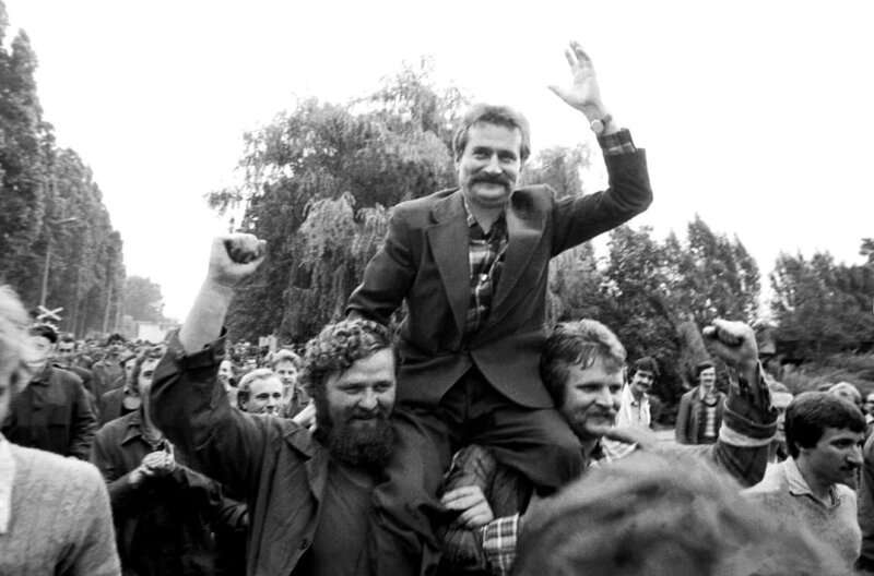 Lech Wałęsa wird während eines Streiks in der Lenin-Werft in Danzig, Polen, im August 1980 von seinen Genossen aus der Gewerkschaft „Solidarität“ auf den Schultern getragen. – Bild: Stringer/​Reuters