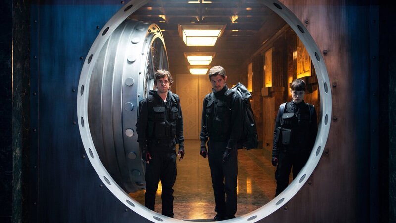 Thom, l. (Freddie Highmore), James, M. (Sam Riley) und Lorraine, r. (Ŕstrid Bergčs-Frisbey) brechen in den Tresorraum der Bank von Spanien ein. – Bild: ZDF Thom, l. (Freddie Highmore), James, M. (Sam Riley) und Lorraine, r. (Ŕstrid Bergčs-Frisbey) brechen in den Tresorraum der Bank von Spanien ein. – Bild: ZDF