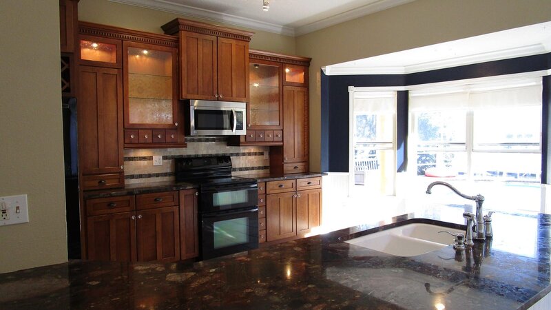 Although fully updated, this dark kitchen is a stark contrast to the sunny Tampa, Florida outdoors, visible through the sliding doors to the deck, as seen on HGTV.s House Hunters. – Bild: HGTV/​Scripps Networks, LLC.