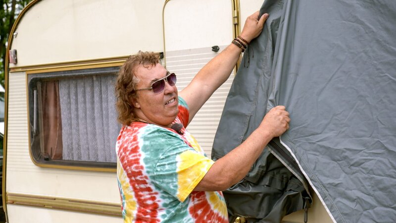 Der Mann nimmt die Abdeckung des Wohnmobils ab – Bild: Warner Bros. Discovery