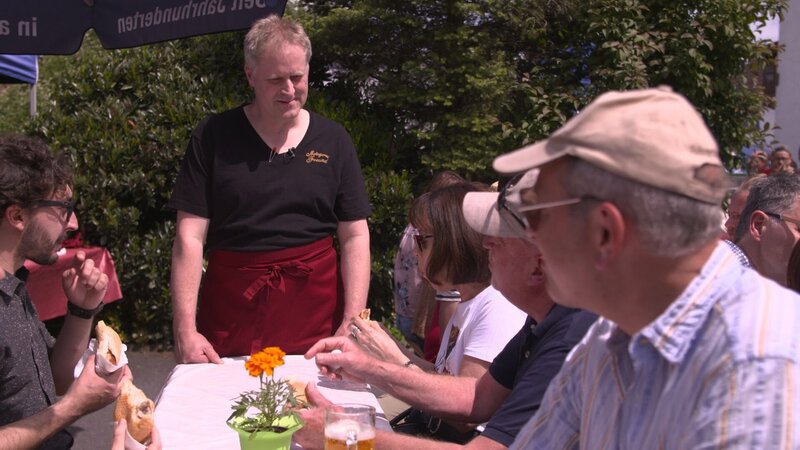 Matthias Freund begrüßt Gäste auf dem Bratwurst-Festival. – Bild: BR/​south & browse GmbH /​ Bayerischer Rundfunk