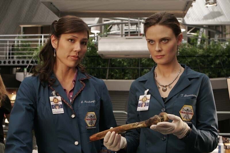 BONES:  Brennan (Emily Deschanel, R) and Angela (Michaela Conlin, L) examine a burned corpse in the BONES season two premiere episode „The Titan on the Tracks“ airing Wednesday, Aug. 30 (8:00⁠–⁠9:00 PM ET/​PT) on FOX.  ©2006 Fox Broadcasting Co.  Cr:  Carin Baer/​FOX – Bild: TV4