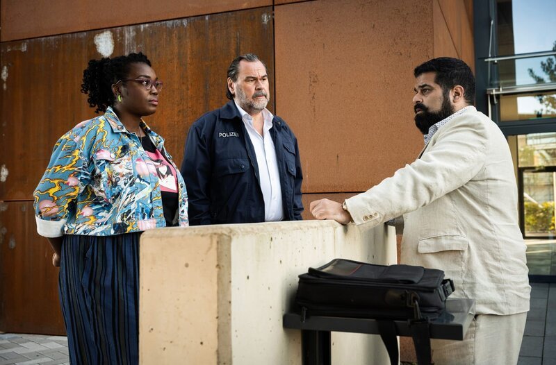 Lena (Romy Vreden, l.) und Gerhard Jäger (Markus John, M.) sprechen mit Malik Hammami (Mohammad Ahmadi, r.). – Bild: ARD/​Martin Valentin Menke