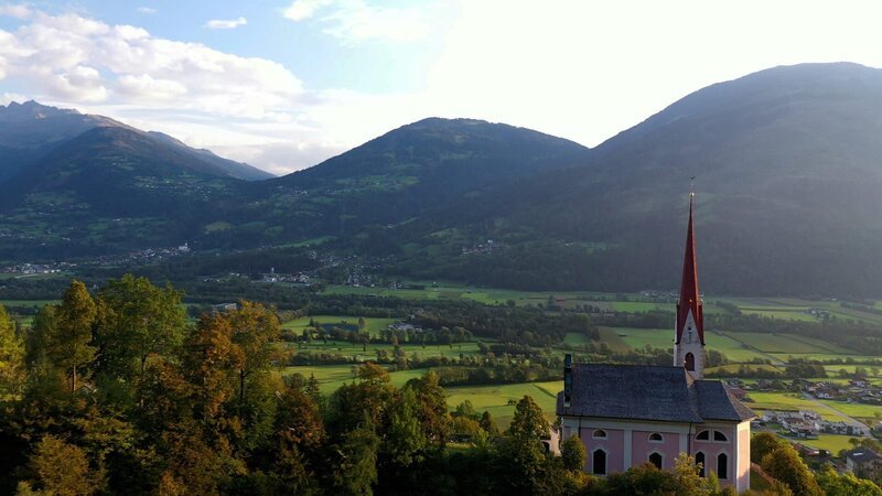 Landschaftsaufnahme mit der Wallfahrtskirche St.Ulrich, Osttirol, Österreich am 28. Juli 2021 – Bild: ServusTV /​ www.redbullmediahouse.com