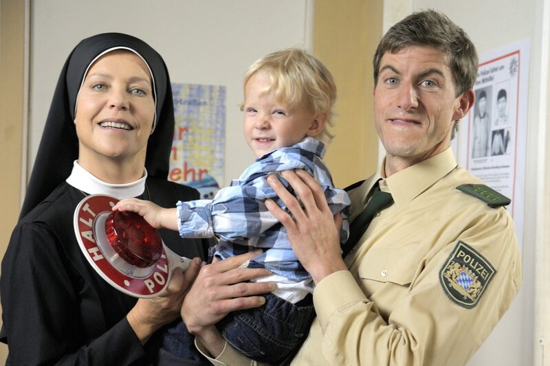 „Um Himmels Willen“, „Ende der Fahnenstange.“ Wachtmeister Meier bringt Renate Kistler im Kloster vorbei. Die angehende Krankenschwester hat ihre Wohnung verloren, weil sie ihre Miete nicht mehr bezahlen konnte. Schwester Hanna versucht Meier zu einer Lösung zu überreden, von der sowohl Renate als auch er profitieren. Indes muss Wöller wegen einer Schmiergeldaffäre sein Müllverbrennungsanlage-Projekt endgültig begraben. Damit ist wohl auch der Verkauf des Klosters hinfällig und die Wahl einer neuer Oberin, für die auch Hanna im Gespräch ist.Im Bild (v.li.): Janina Hartwig (Hanna Jakobi), Louis Werner (Junior Meier), Lars Weström (Polizist Meier). – Bild: ORF/​Kineos/​Jacqueline Krause-Burberg