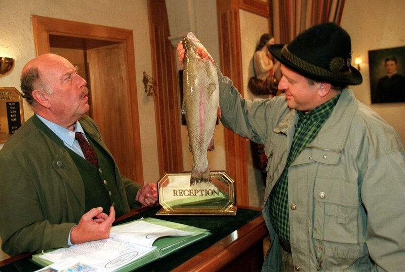 „Schlosshotel Orth“, „Anglerlatein.“ Die sagenhafte Riesenforelle Diana lockt die beiden Weinbauern Winkler und Ziegelberger zum Fischfang an den Traunsee. Die beiden konkurrieren um die Trophäe nicht nur mit fragwürdigen Tipps und faulen Tricks. Es trennt sie auch eine gänzlich unterschiedliche Auffassung über die Produktion von Qualitätsweinen. Im Bild (v.li.): Hans Kraemmer (Josef Schimek), Vitus Zeplichal (Herr Ziegelberger). – Bild: ORF/​Johannes Cizek